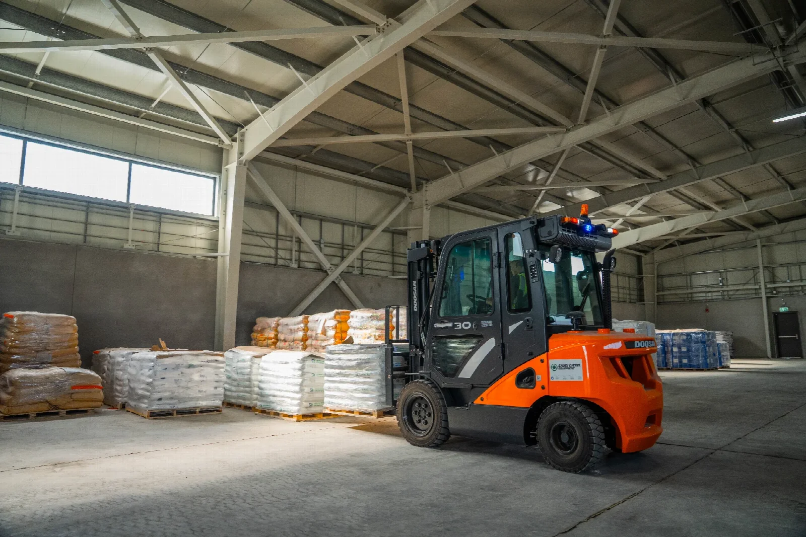 Palletised goods and a forklift inside a SPARK warehouse